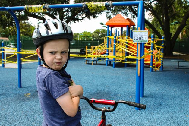 Angry boy at the closed playground