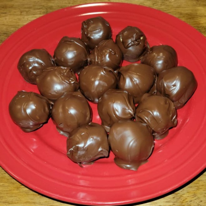A red plate of chocolate peanut butter balls