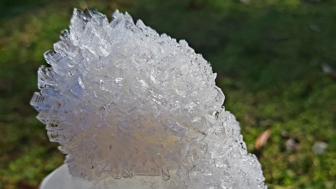 Ice crystals atop a frozen jug of water