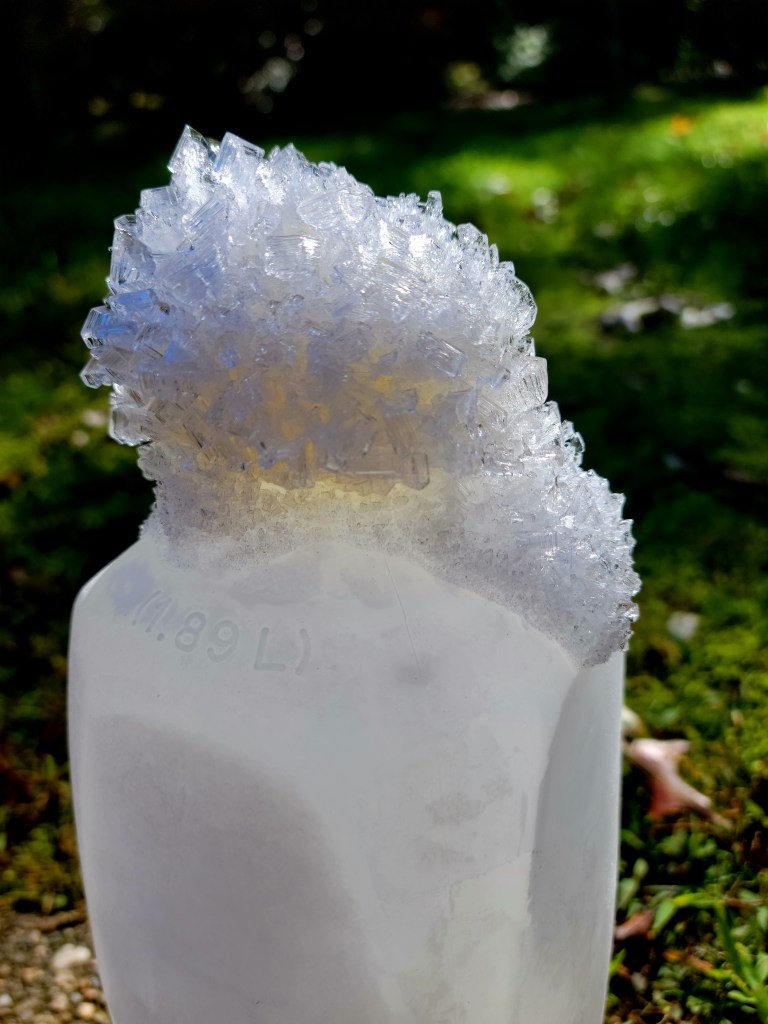 Ice crystals growing atop a frozen jug of water