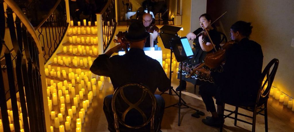 String Quartet playing while surrounded by lit candles